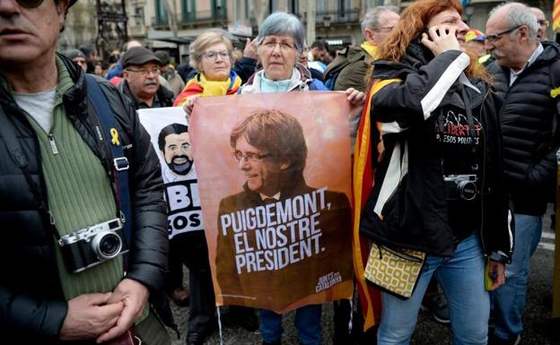 Una mujer muestra un cartel en apoyo a Puigdemont en Barcelona. /Afp