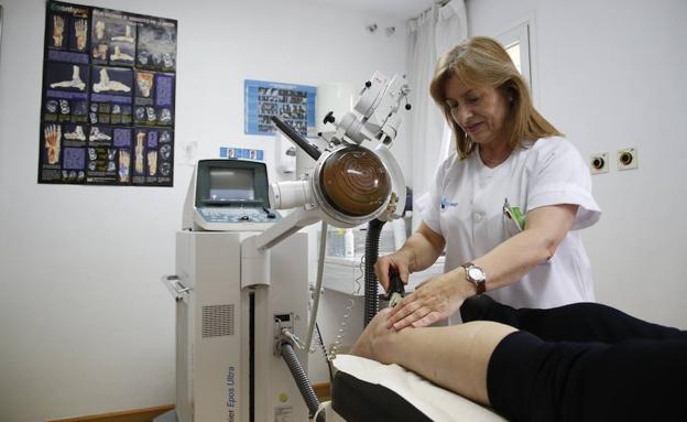 Personal de la Unidad del Dolor aplica a una paciente el tratamiento mediante ondas de choque extracorporeo, que fue pionera en España. /LAYA