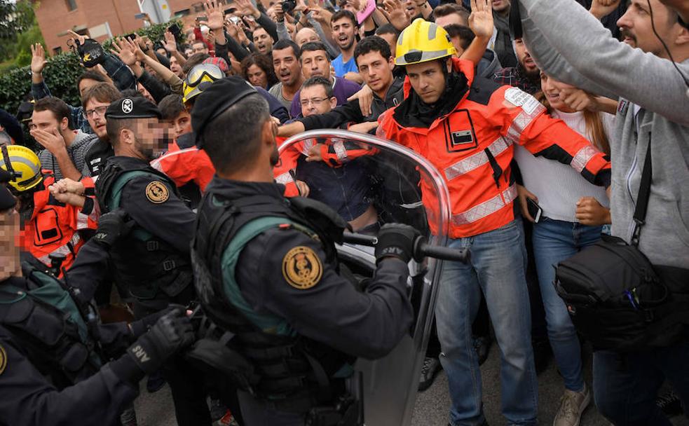 Partidarios del referéndum increpan a la Guardia Civil en San Julià de Ramis, el lugar donde debÃa votar Carles Puigdemont el 1-O./AFP